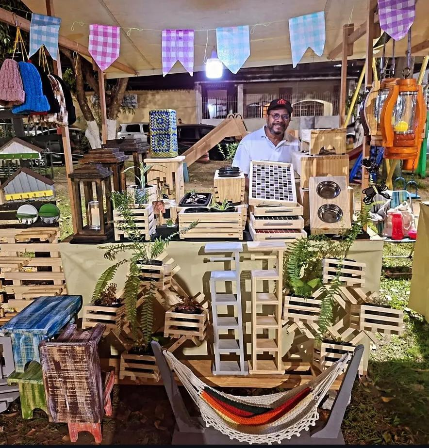 Ailton Mendes com suas peças artesanais em madeira na Praça João Petini